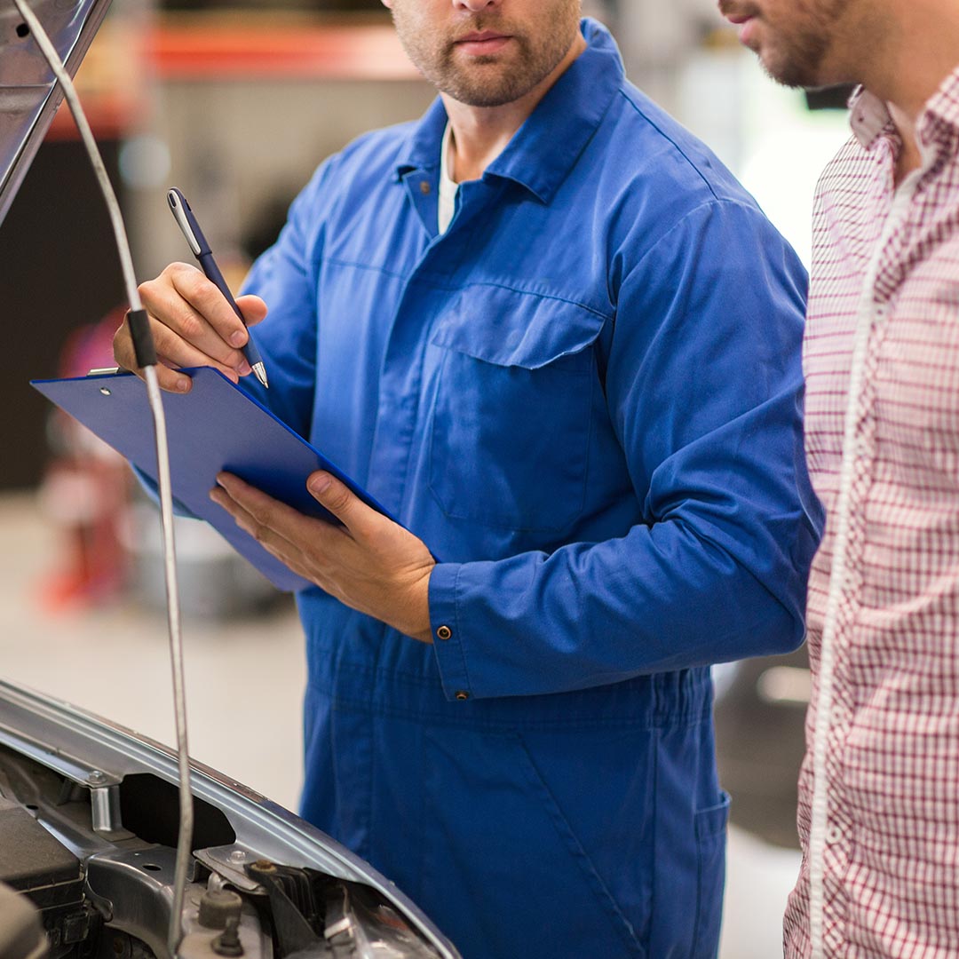 mechanic going over checklist with customer